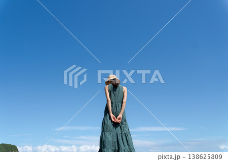 青空の下で帽子をかぶった女性 138625809