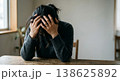 机に伏せて頭を抱えるストレスを感じる女性の姿 138625892