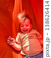 Smiling toddler on bright orange playground slide 138626414