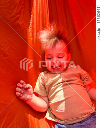 Smiling toddler on bright orange playground slide Smiling toddler on bright orange playground slide 138626414