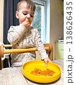 Toddler self-feeding messy meal in high chair 138626435