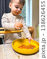 Toddler self-feeding messy meal in high chair 138626455