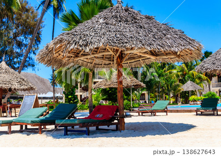 Sun umbrellas and chaise lounges on tropical beach. Concept of rest, relaxation, holidays, resort 138627643