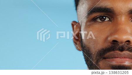 Half, face and serious black man in studio, blue background and mockup space with confidence or advertising. Portrait, closeup and marketing for skincare, wellness or healthy dermatology care Half, face and serious black man in studio, blue background and mockup space with confidence or advertising. Portrait, closeup and marketing for skincare, wellness or healthy dermatology care 138631205