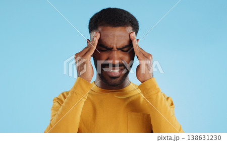 Stress, tired and a man with headache pain on a blue background from burnout or anxiety. Mental health, fatigue and a person with a migraine massage, frustrated and with depression and anger Stress, tired and a man with headache pain on a blue background from burnout or anxiety. Mental health, fatigue and a person with a migraine massage, frustrated and with depression and anger 138631230