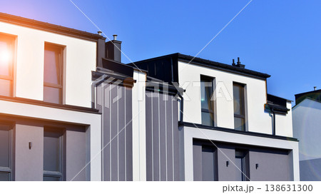 The real estate market in the suburbs. Terraced family homes in newly developed housing estate. New single family houses in a new development area. Residential homes with modern facade. The real estate market in the suburbs. Terraced family homes in newly developed housing estate. New single family houses in a new development area. Residential homes with modern facade. 138631300