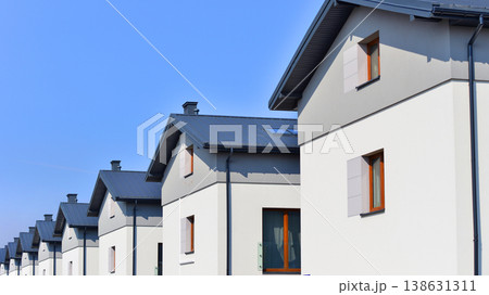 The real estate market in the suburbs. Terraced family homes in newly developed housing estate. New single family houses in a new development area. Residential homes with modern facade.  138631311
