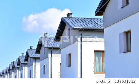 The real estate market in the suburbs. Terraced family homes in newly developed housing estate. New single family houses in a new development area. Residential homes with modern facade.  138631312