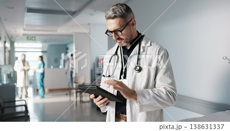Doctor, hospital and tablet for medical information, typing and management of online charts or results. Healthcare worker, man or expert with digital technology for health services, planning and data 138631337