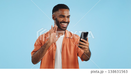 Video call, wave and man with a smartphone, showing and conversation on a blue studio background. Person, speaking and model with a cellphone, online chat and communication with network or connection Video call, wave and man with a smartphone, showing and conversation on a blue studio background. Person, speaking and model with a cellphone, online chat and communication with network or connection 138631563