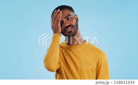 Stress, fail and man in studio with facepalm emoji for stupid mistake or regret on blue background. Anxiety, oops and male model with disaster, crisis or fake news shame, frustrated and unhappy 138631834