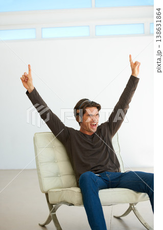 Happy, headphones and young man on a chair listening to music, playlist or radio at home. Excited, scream and male person streaming a song or album for singing karaoke in modern apartment or house. Happy, headphones and young man on a chair listening to music, playlist or radio at home. Excited, scream and male person streaming a song or album for singing karaoke in modern apartment or house. 138631864