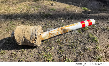 Damaged Metal Parking Bollard with Concrete Base on Ground 138632468