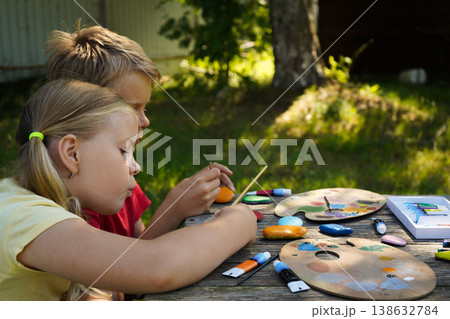 Colorful paint transforms simple stones into playful scenes, crafted by childrens hands into personalized presents. Colorful paint transforms simple stones into playful scenes, crafted by childrens hands into personalized presents. 138632784