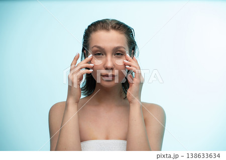 Woman applying under eye patches, creating a refreshing skincare routine, nurturing her face with cosmetic treatment for beauty and wellness 138633634