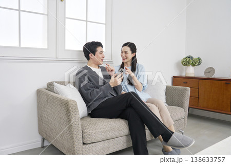 リビングでスマホを持って会話するカップル 138633757