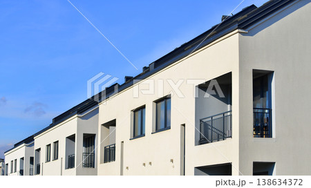 Terraced family homes in newly developed housing estate. The real estate market in the suburbs. New single family houses in a new development area. Residential homes with modern facade.  138634372