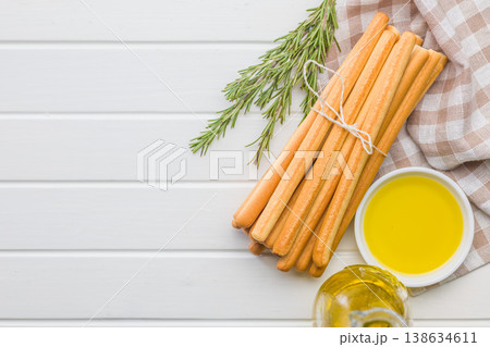 Bundle Of Crispy Breadsticks With Rosemary And Olive Oil Dip On White Wooden Table Bundle Of Crispy Breadsticks With Rosemary And Olive Oil Dip On White Wooden Table 138634611