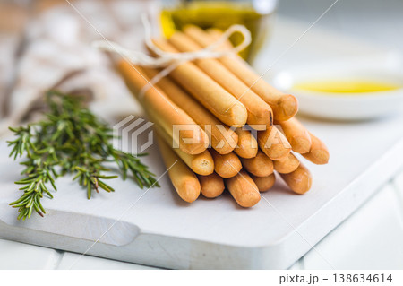 Bundle Of Crispy Breadsticks With Rosemary And Olive Oil Dip On White Wooden Table Bundle Of Crispy Breadsticks With Rosemary And Olive Oil Dip On White Wooden Table 138634614
