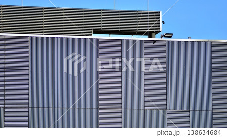 The futuristic building has engineered vertical cladding steel frame panels. The exterior wall of a contemporary commercial style building with aluminum metal composite panels.  138634684