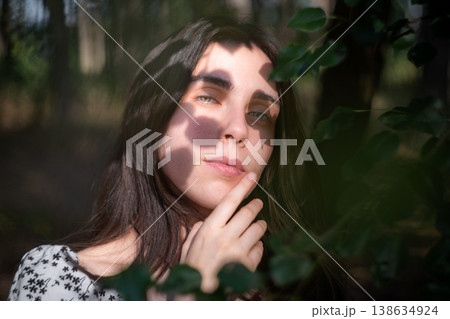 Artistic portrait of young woman framed by leaves Artistic portrait of young woman framed by leaves 138634924