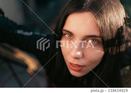 Young woman close portrait with direct gaze in warm outdoor light 138634929