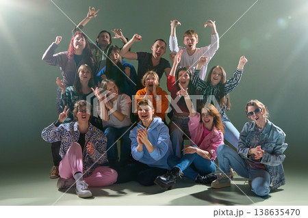 Group of young people cheering loudly and reacting together with high energy in studio. 138635470