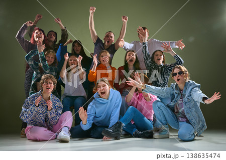 Excited diverse group expressing strong emotions and cheering in studio environment. Excited diverse group expressing strong emotions and cheering in studio environment. 138635474