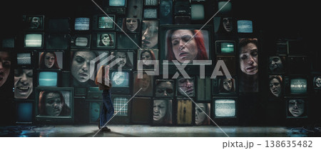 Woman surrounded by wall of retro televisions showing intense emotional expressions 138635482