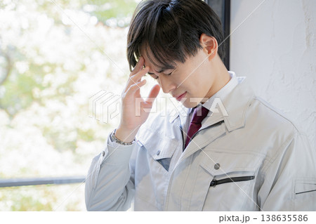 頭を抱える作業着の男性　ビジネス 138635586