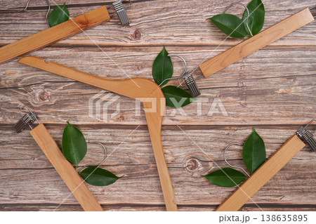 Wooden hangers with green leaves on rustic background 138635895