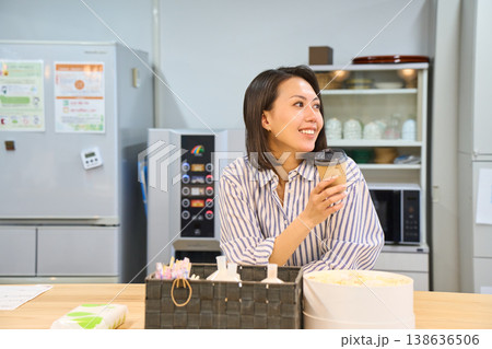 休憩スペースでパソコン作業の合間にコーヒーでひと息つくビジネスウーマン 休憩スペースでパソコン作業の合間にコーヒーでひと息つくビジネスウーマン 138636506