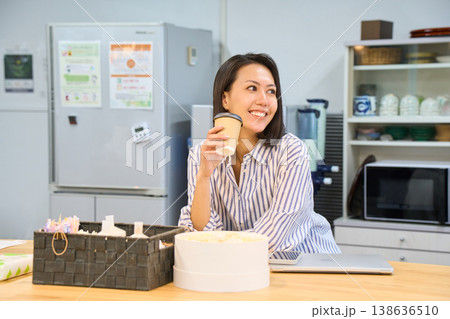 休憩スペースでパソコン作業の合間にコーヒーでひと息つくビジネスウーマン 138636510