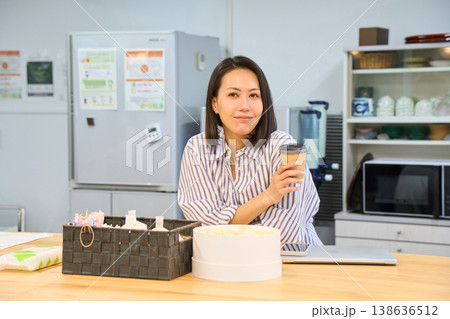 休憩スペースでパソコン作業の合間にコーヒーでひと息つくビジネスウーマン 休憩スペースでパソコン作業の合間にコーヒーでひと息つくビジネスウーマン 138636512