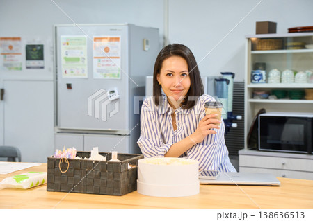 休憩スペースでパソコン作業の合間にコーヒーでひと息つくビジネスウーマン 138636513