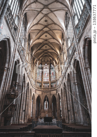Visitors explore the gothic interior of St. Vitus Cathedral at Prague Castle. Tall arches and stained glass windows create a historic atmosphere in this famous location. Visitors explore the gothic interior of St. Vitus Cathedral at Prague Castle. Tall arches and stained glass windows create a historic atmosphere in this famous location. 138637771