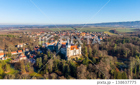 A drone captures Zleby Castle surrounded by trees and fields. The castle stands tall beside a small town, showcasing the historic architecture among the natural landscape, revealing its grandeur. A drone captures Zleby Castle surrounded by trees and fields. The castle stands tall beside a small town, showcasing the historic architecture among the natural landscape, revealing its grandeur. 138637775