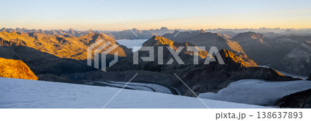 Early morning sunlight casts a warm glow on Pers Glacier in the Bernina Range. The Swiss Alps showcase majestic peaks and sweeping valleys, creating a breathtaking alpine view. 138637893