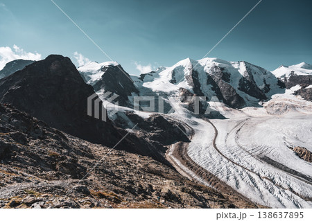 The striking landscape showcases Piz Palu towering over the Pers Glacier, with rocky ridges beneath a clear blue sky. This breathtaking scene exemplifies the beauty of the Swiss Alps. The striking landscape showcases Piz Palu towering over the Pers Glacier, with rocky ridges beneath a clear blue sky. This breathtaking scene exemplifies the beauty of the Swiss Alps. 138637895