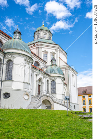 St. Lorenz Basilica features stunning baroque architecture, set against a vivid blue sky. The basilica is located in Kempten, Bavaria, surrounded by lush green lawns. 138637928