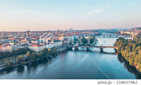 Aerial view of the Vltava River winding through Prague at sunset, showcasing the National Theatre. Diverse architecture and lively atmosphere reflect the city's charm and history. Aerial view of the Vltava River winding through Prague at sunset, showcasing the National Theatre. Diverse architecture and lively atmosphere reflect the city's charm and history. 138637962