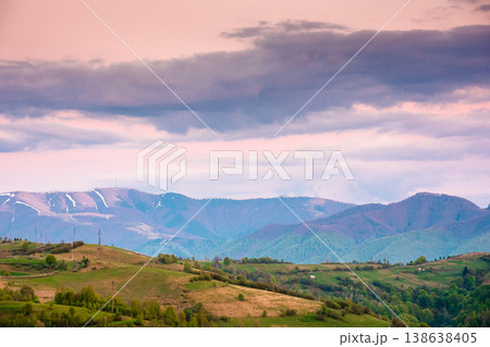 dusk over mountainous countryside scenery. dramatic sky above the distant valley and ridge. remote green meadows and trees on rolling hills. beautiful nature landscape of carpathians during spring dusk over mountainous countryside scenery. dramatic sky above the distant valley and ridge. remote green meadows and trees on rolling hills. beautiful nature landscape of carpathians during spring 138638405
