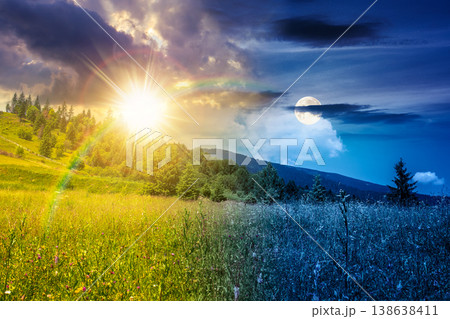 day meet night. mountainous countryside landscape on summer solstice. grassy field on a hillside. view of a forested mountain ridge in the distance. wonderful weather with cloudy sky. harmony concept 138638411