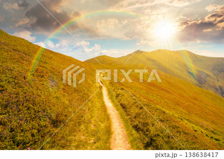 sunset over summer landscape. mountain path through the grassy slope turns uphill to the sky with rainbow. scenic view. hiking trail path through borzhava ridge. travel ukraine mountains concept 138638417