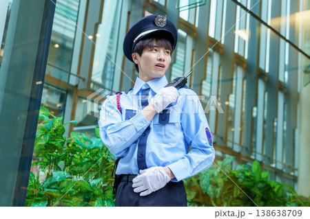 トランシーバーで会話する若い日本人男性警備員　撮影協力：学校法人電波学園　東京電子専門学校 138638709