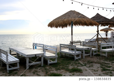 Chairs and tables row on beach with sunset. Chairs and tables row on beach with sunset. 138638835