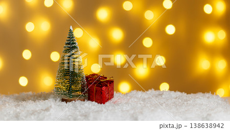 Christmas tree in snow with gifts on glowing lights bokeh background Christmas tree in snow with gifts on glowing lights bokeh background 138638942
