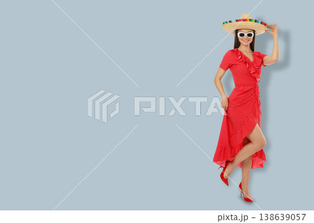 Cinco de Mayo, A young woman wears a red dress and holds a sombrero 138639057