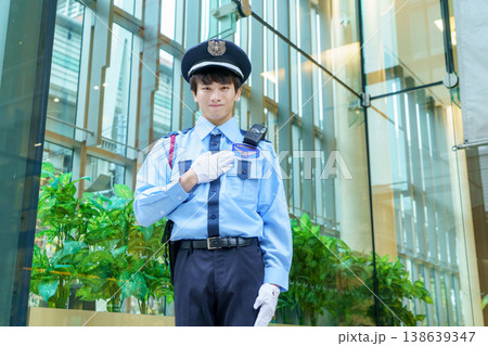 胸に手を当てる若い日本人男性警備員　撮影協力：学校法人電波学園　東京電子専門学校 138639347