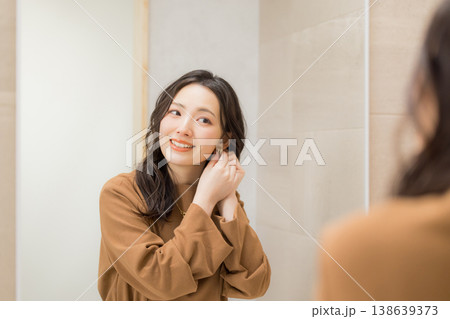 洗面所で肌の調子を確認する若い女性 洗面所で肌の調子を確認する若い女性 138639373